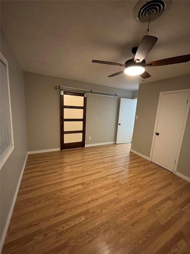 509 W 3rd St, Claude, TX 79019 - unfurnished bedroom featuring a ceiling fan, visible vents, light wood-style flooring, and baseboards
