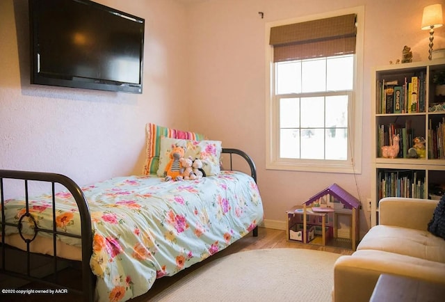 509 W 3rd St, Claude, TX 79019 - bedroom with baseboards and wood finished floors