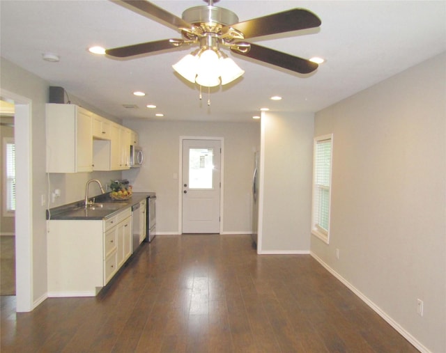 316 Tennessee St, Graham, TX 76450 - kitchen featuring a sink, stainless steel appliances, ceiling fan, baseboards, and dark countertops