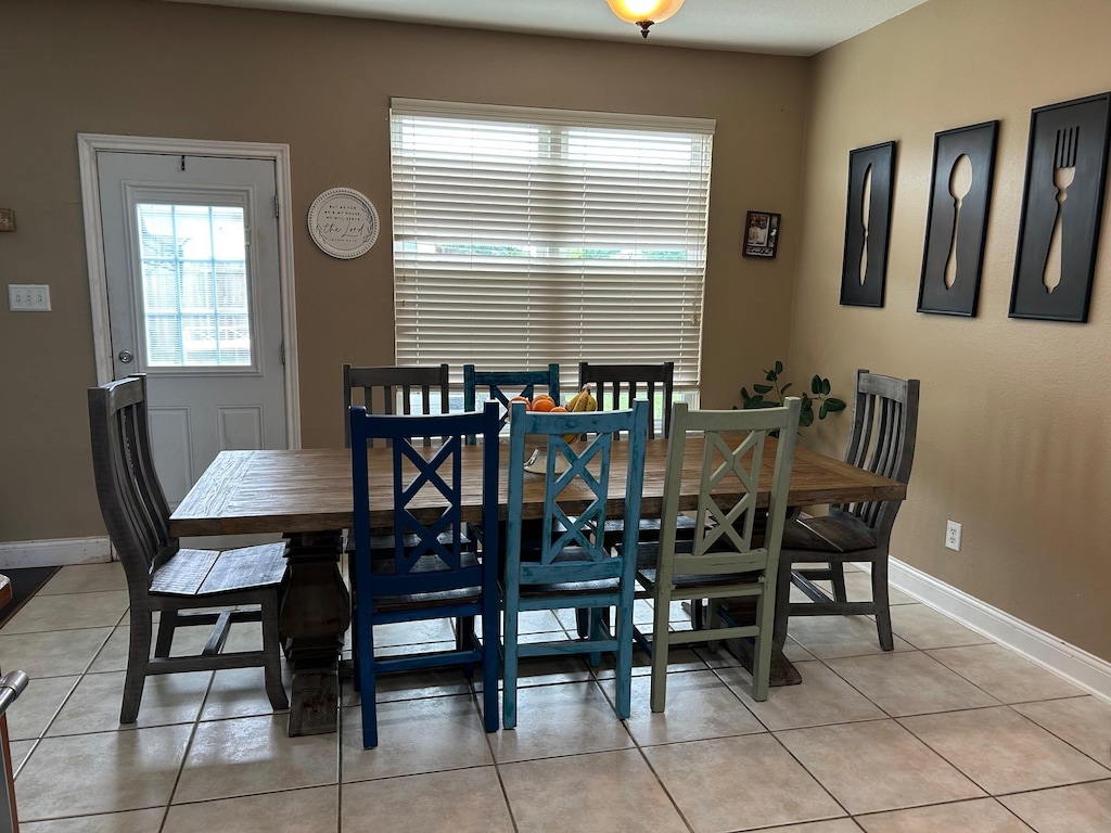 dining room featuring light tile patterned floors, baseboards, and a wealth of natural light