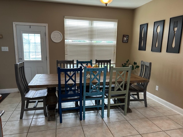 dining room featuring light tile patterned floors, baseboards, and a wealth of natural light