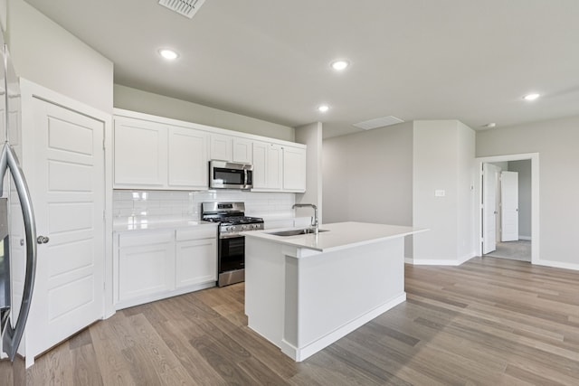 6517 Colt Ranch Rd, Fort Worth, TX 76036 - kitchen with appliances with stainless steel finishes, light wood-style flooring, backsplash, white cabinets, and recessed lighting