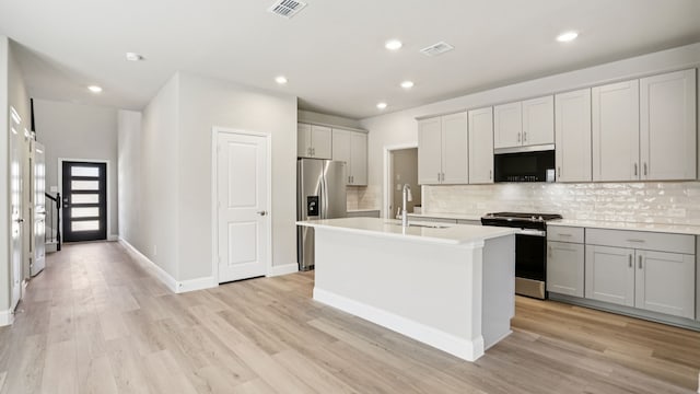418 Ezra Ln, Mckinney, TX 75069 - kitchen featuring stainless steel appliances, light wood-style floors, tasteful backsplash, light countertops, and recessed lighting