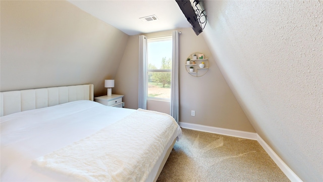 carpeted bedroom featuring baseboards, visible vents, and lofted ceiling