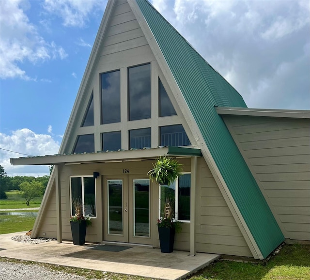 124 Greenhill Cir, Nocona, TX 76255 - rear view of property with metal roof and french doors