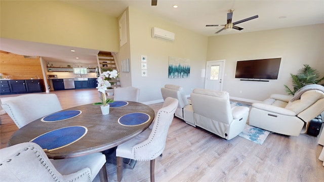 dining space with ceiling fan, light wood finished floors, a wall mounted AC, baseboards, and high vaulted ceiling