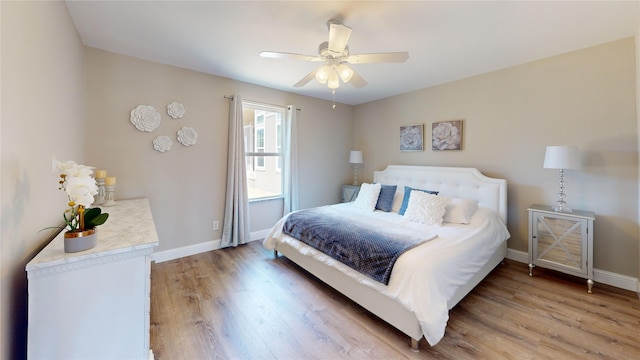 bedroom with a ceiling fan, light wood finished floors, and baseboards