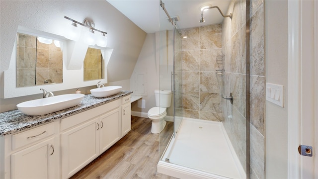 full bath with wood finished floors, a shower stall, toilet, and a sink