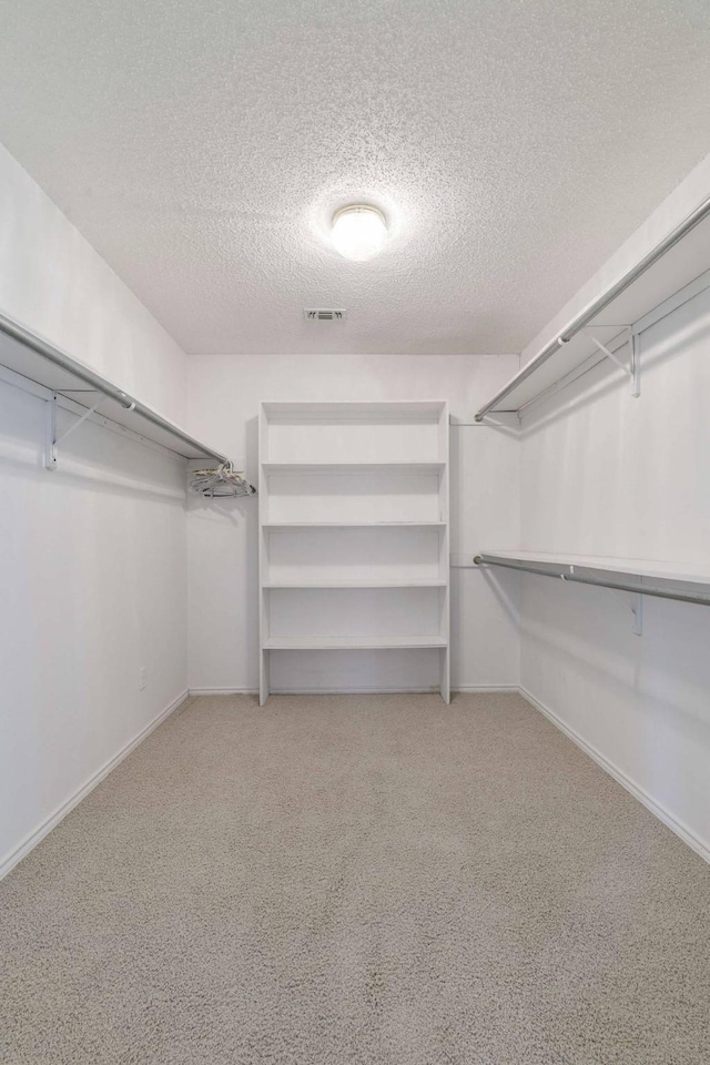 spacious closet featuring visible vents and carpet floors