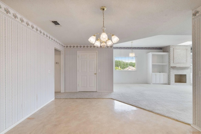 unfurnished dining area with an inviting chandelier, carpet floors, wallpapered walls, visible vents, and a textured ceiling