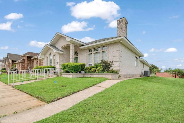 view of front of home featuring brick siding, a chimney, a front lawn, and central AC unit