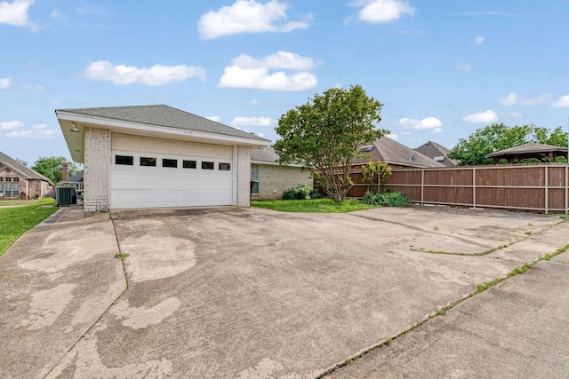exterior space featuring a garage, fence, and central air condition unit
