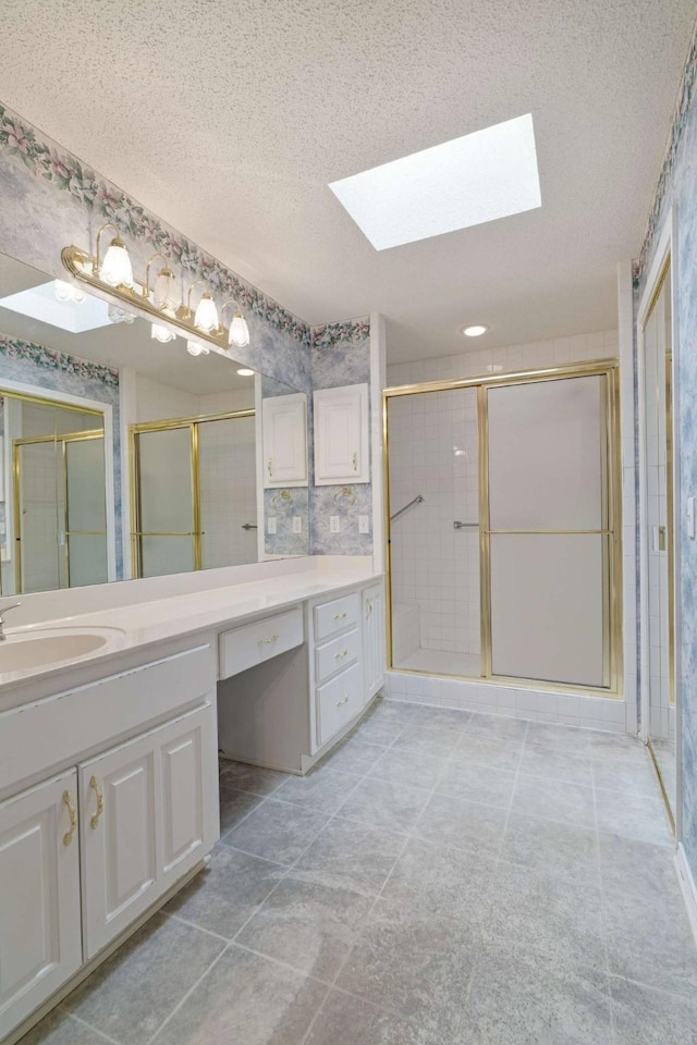 bathroom with a skylight, a textured ceiling, and a stall shower