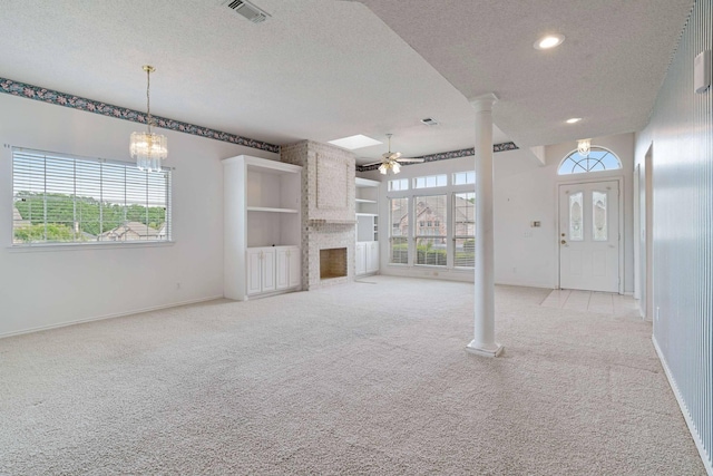 unfurnished living room featuring a textured ceiling, light colored carpet, ceiling fan, visible vents, and a fireplace