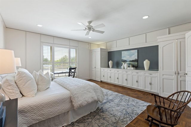 bedroom with a decorative wall, recessed lighting, and a ceiling fan