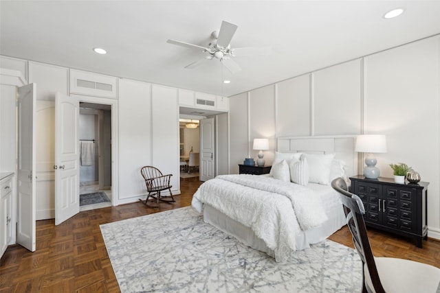 bedroom featuring visible vents, recessed lighting, and a decorative wall