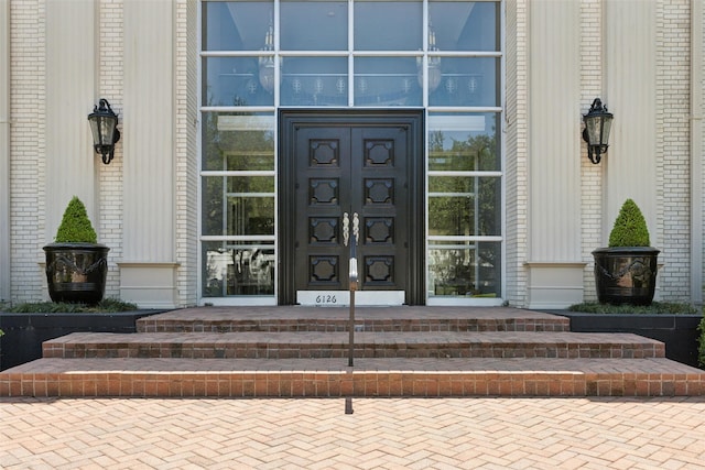 doorway to property with covered porch and brick siding