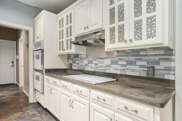 7324 Old Mill Run, Fort Worth, TX 76133 - kitchen featuring stone finish floor, under cabinet range hood, cooktop, backsplash, and dark countertops