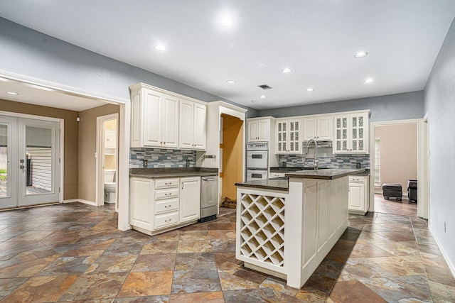 7324 Old Mill Run, Fort Worth, TX 76133 - kitchen featuring dark countertops, stone tile floors, and white double oven