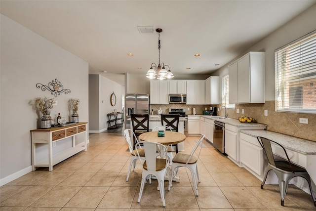 2925 Clear Creek Dr, Rockwall, TX 75032 - kitchen featuring decorative backsplash, appliances with stainless steel finishes, a sink, visible vents, and a notable chandelier