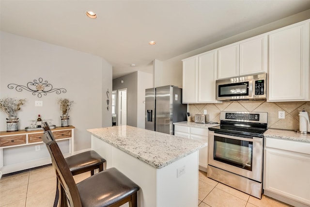 2925 Clear Creek Dr, Rockwall, TX 75032 - kitchen with light tile patterned floors, a center island, appliances with stainless steel finishes, and decorative backsplash