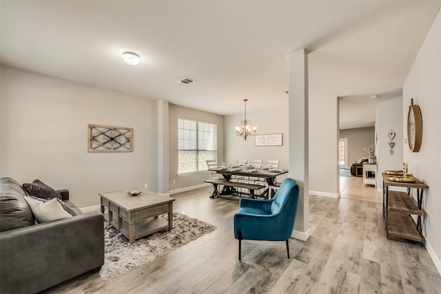 2925 Clear Creek Dr, Rockwall, TX 75032 - living area featuring light wood finished floors, an inviting chandelier, visible vents, and baseboards
