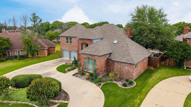 view of front of property with fence, an attached garage, brick siding, a front yard, and driveway