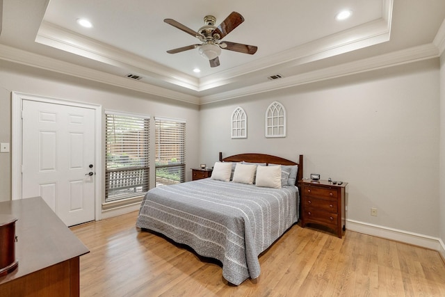 bedroom with ornamental molding, a tray ceiling, and visible vents