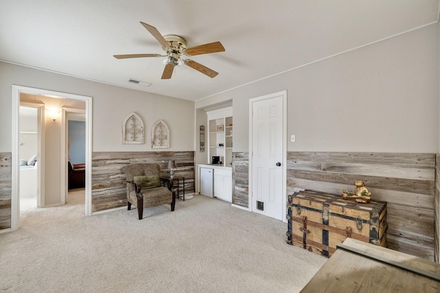 sitting room with carpet flooring, ceiling fan, and visible vents