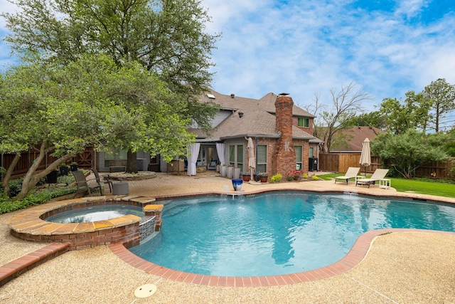view of pool featuring a patio, a fenced backyard, and a pool with connected hot tub