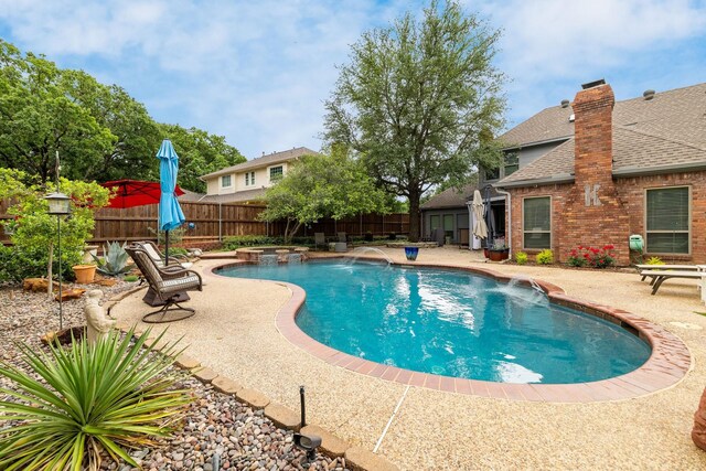 view of pool with a fenced backyard, a patio, and a pool with connected hot tub