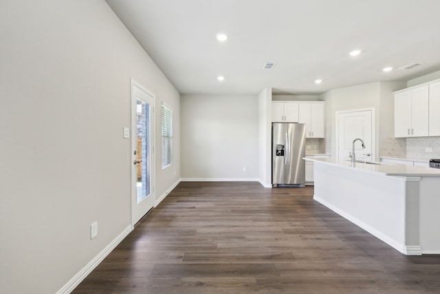 kitchen featuring a sink, tasteful backsplash, light countertops, and stainless steel fridge with ice dispenser
