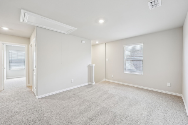 empty room featuring attic access, recessed lighting, visible vents, light carpet, and baseboards