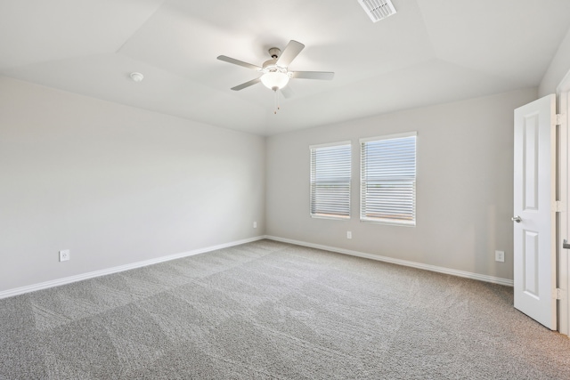 carpeted spare room with baseboards, visible vents, a ceiling fan, and vaulted ceiling