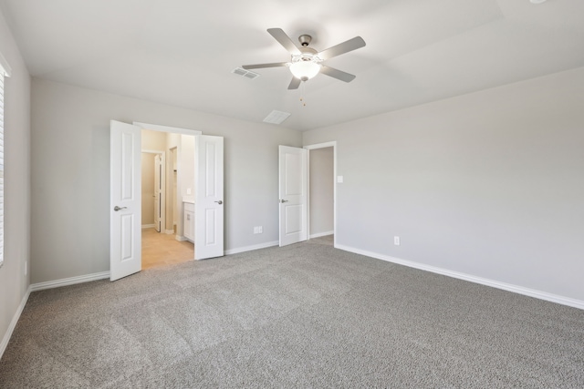 unfurnished bedroom with connected bathroom, ceiling fan, visible vents, baseboards, and light colored carpet