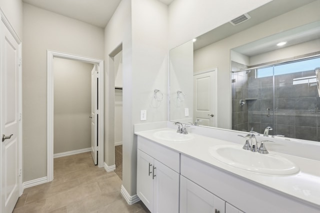 full bath with double vanity, visible vents, a stall shower, and a sink