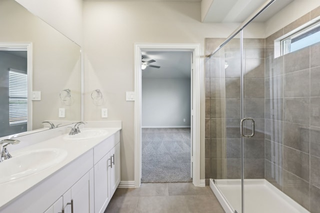 full bath featuring double vanity, a ceiling fan, a stall shower, and a sink