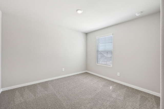 carpeted empty room featuring baseboards