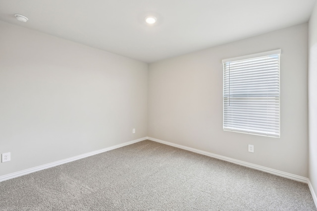 carpeted spare room with baseboards