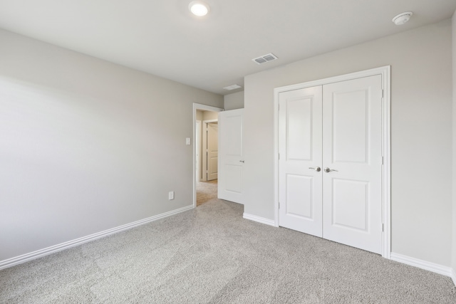 unfurnished bedroom with baseboards, visible vents, carpet floors, and a closet