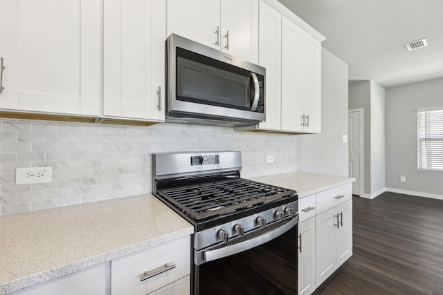 kitchen with baseboards, white cabinetry, stainless steel appliances, dark wood-style floors, and visible vents