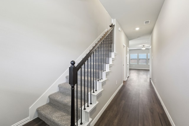 staircase featuring baseboards, visible vents, wood finished floors, and a ceiling fan