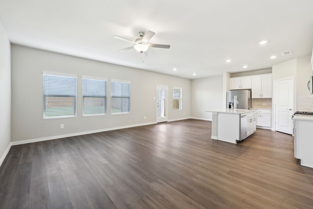unfurnished living room with ceiling fan, visible vents, dark wood-style floors, baseboards, and recessed lighting