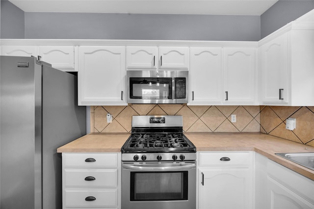 kitchen with white cabinetry, stainless steel appliances, and light countertops