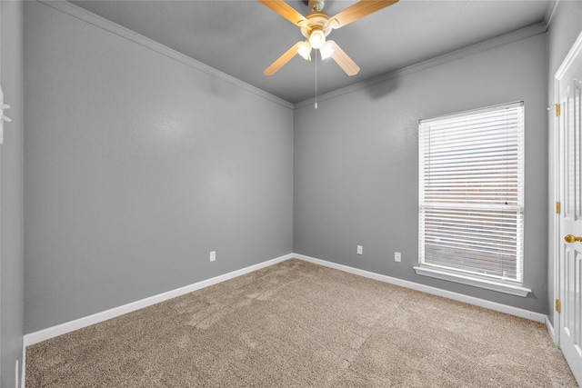 empty room with ceiling fan, baseboards, ornamental molding, and carpet floors