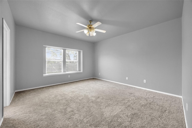 empty room with a ceiling fan, carpet flooring, and baseboards