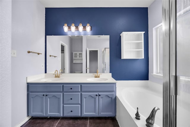 bathroom with double vanity, a bath, tile patterned flooring, and a sink