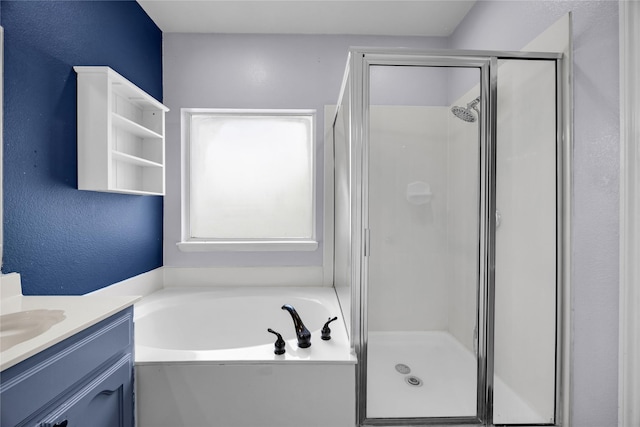 bathroom with a shower stall, a textured wall, a bath, and vanity