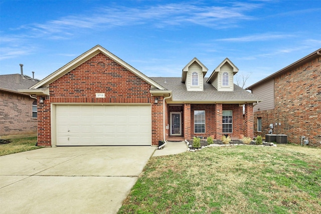 traditional-style home featuring driveway, a shingled roof, a front yard, brick siding, and a garage