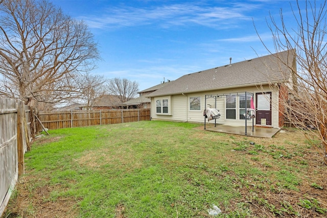 rear view of property featuring a yard, a fenced backyard, and a patio area